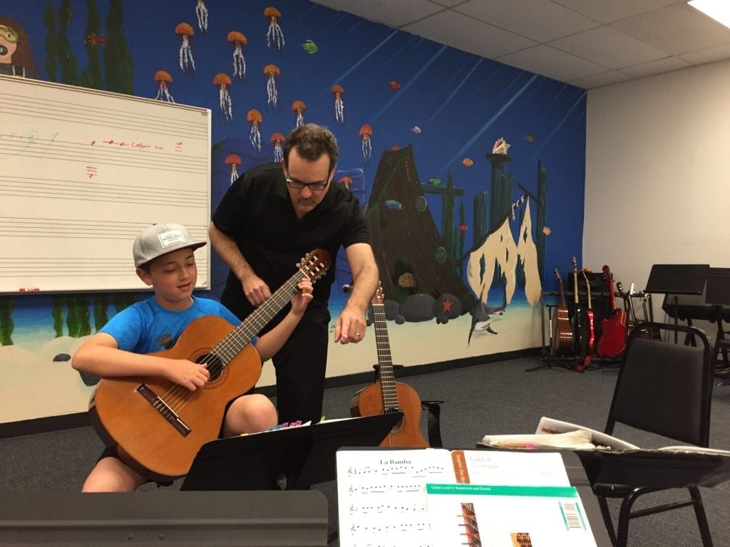 Guitar Teacher and Student in a studio, taking a lesson